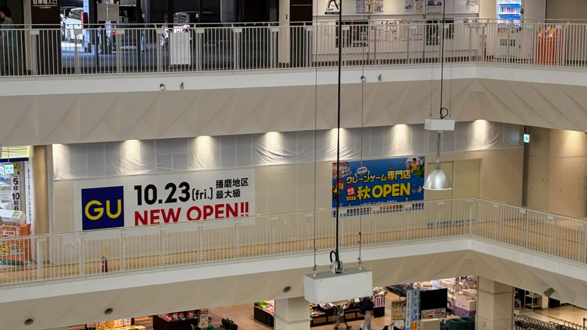 ニッケパークタウン2階に掲示されたGU 加古川ニッケパークタウン店の10月23日オープン告知と、隣に並ぶGiGOクレーンゲーム専門店の告知